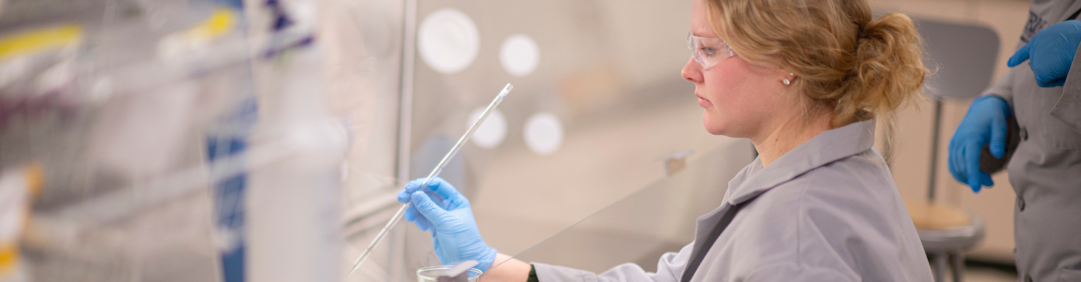 female biomedical engineering student in lab testing substance