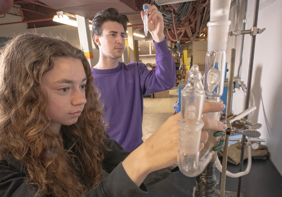 two students checking beakers