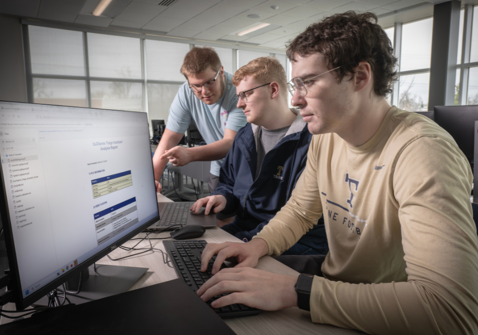three students view digital workflow system
