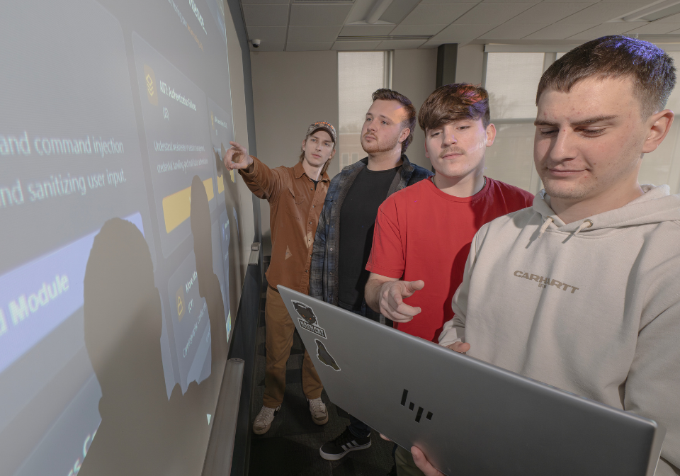 four students view scanner on a projector