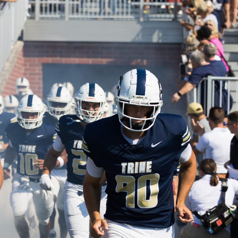 trine football team runs onto the field