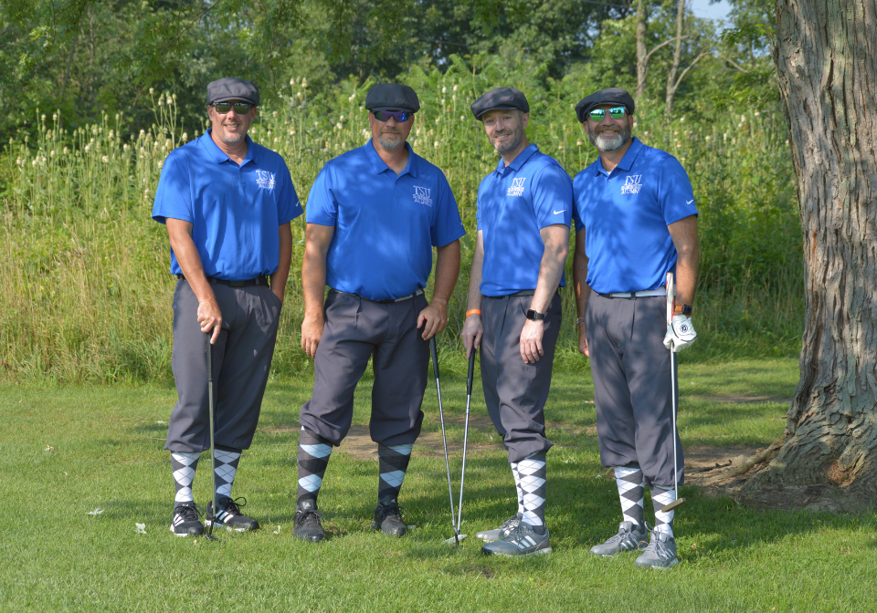 four men match in trine alumni shirts