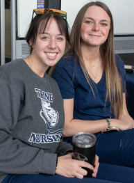 two nursing students smile