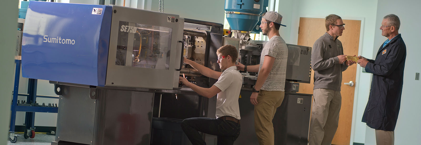 Students and professor working with injection molding