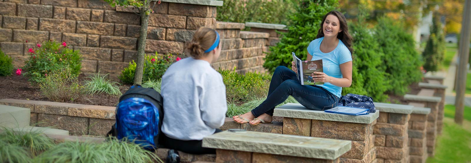 students sitting on decorative wall