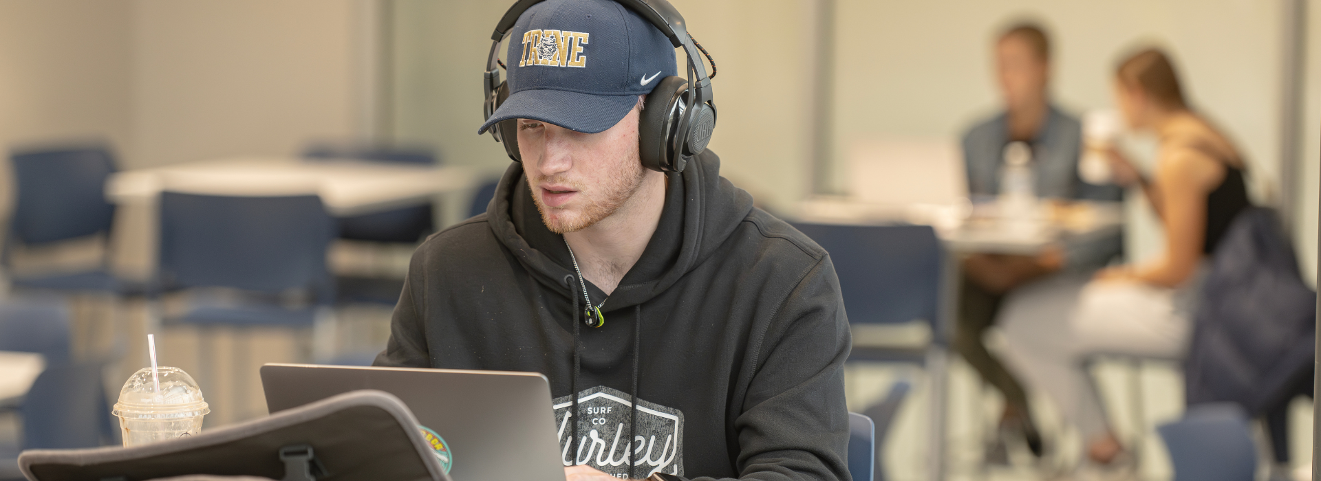trine student studying on a laptop in a cafe