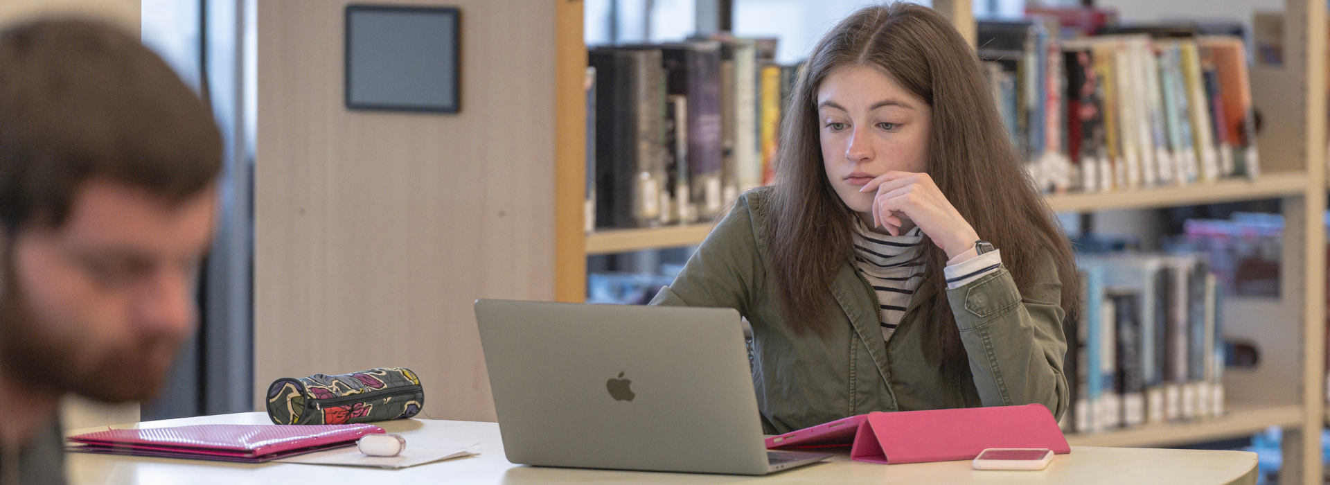 a student studying at a table in the library