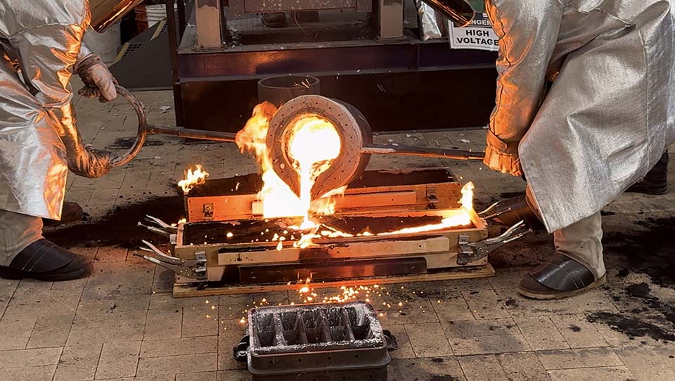 Students pouring metal for replica sword