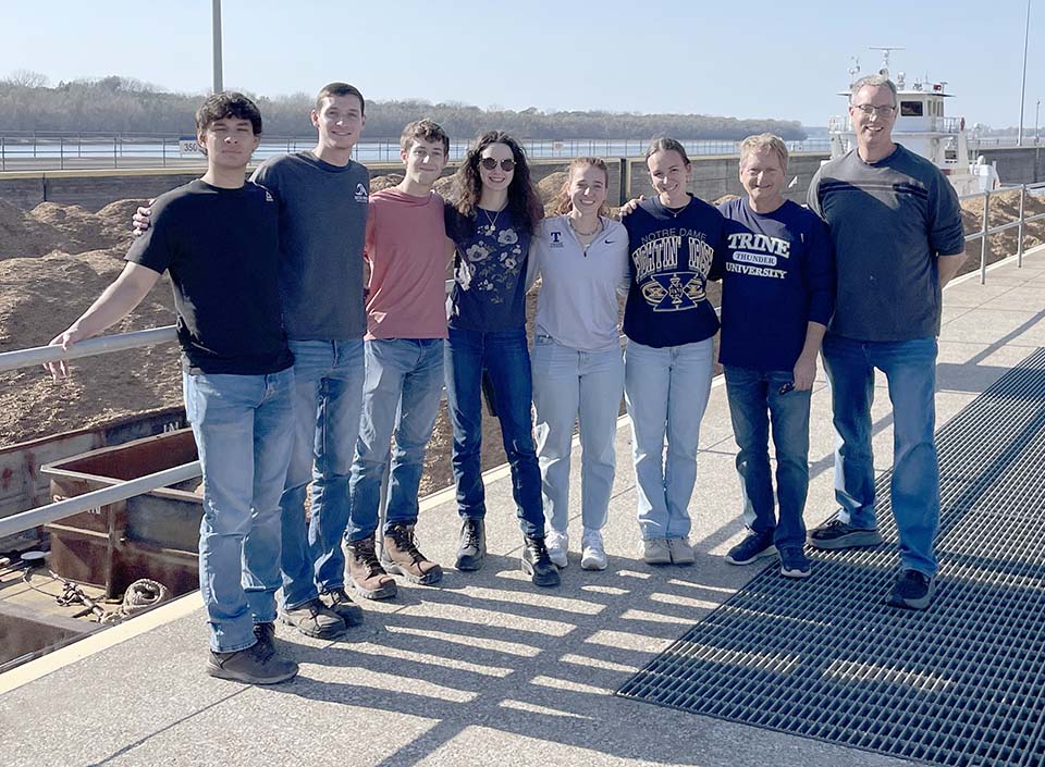 Trine University civil engineering students and faculty standing by lock