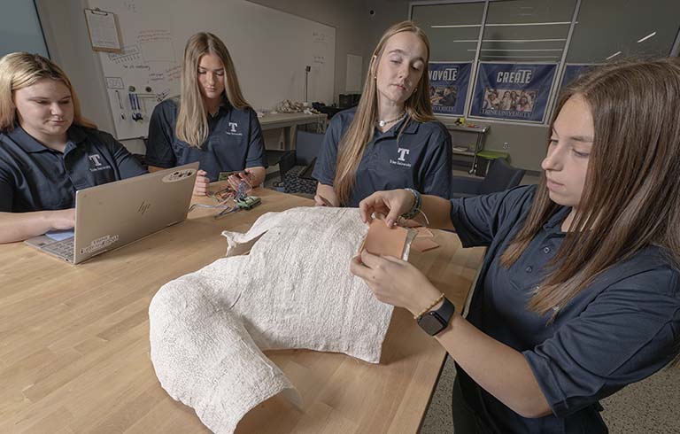 Four female students with central line trainer device