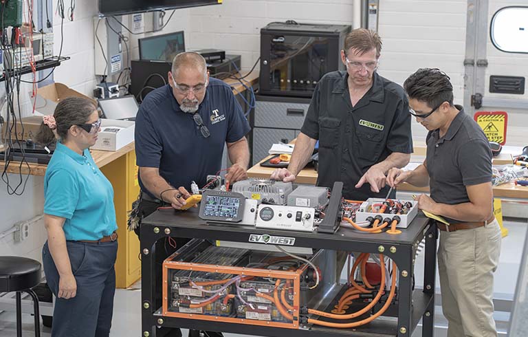 Trine faculty and Mark Weller from EV West training on electric vehicle device