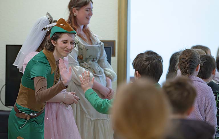 Robin Hood giving a high five to an elementary student