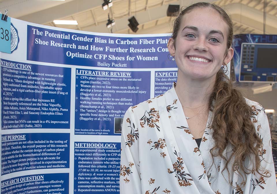 Trine University exercise science student with research poster