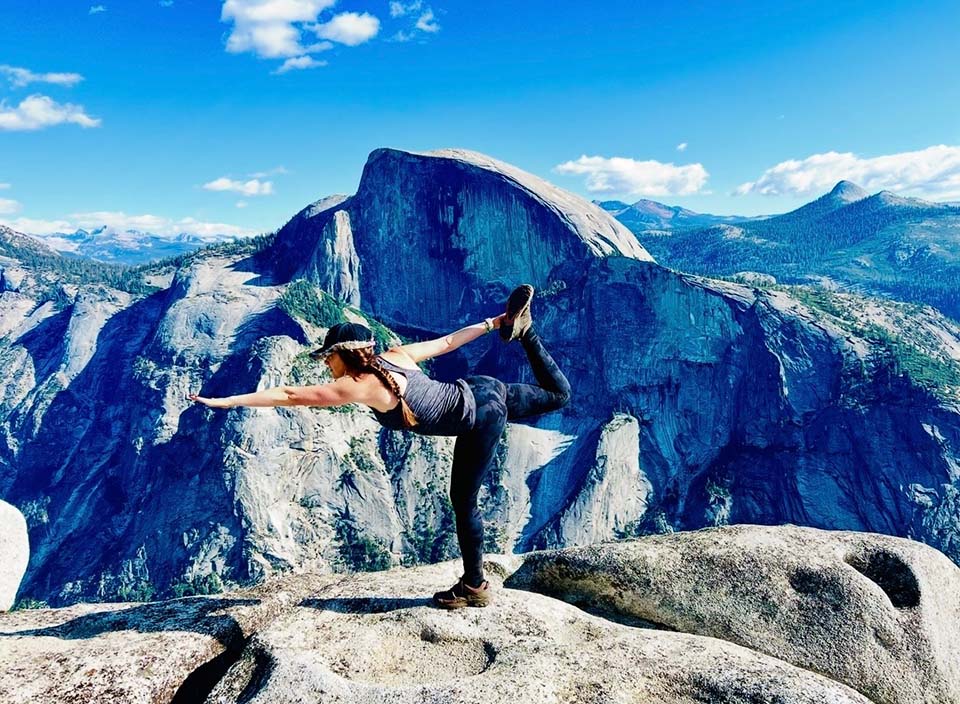 Angela Kesler Santoro stretching on mountaintop.