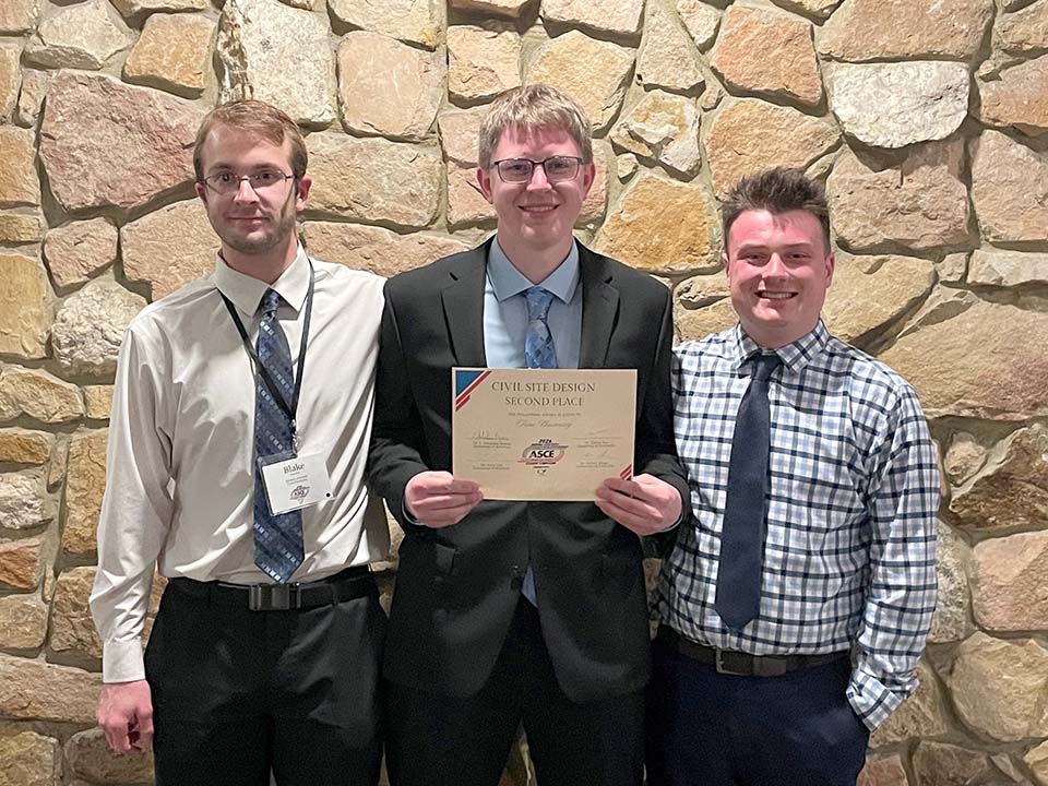 Three students with certificate