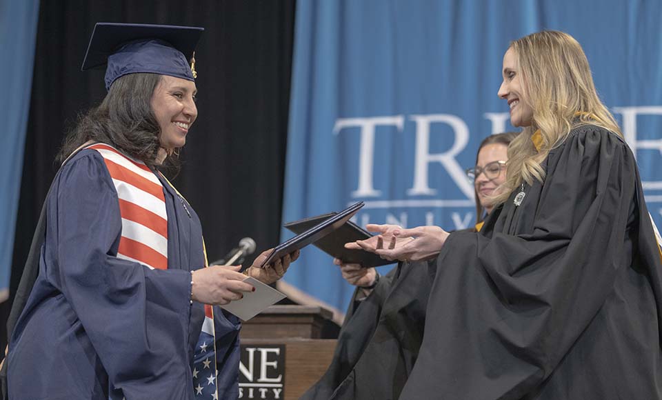 Student receiving diploma from administrator