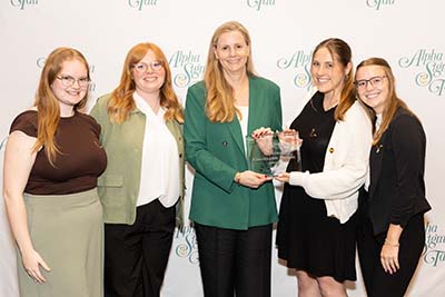 Four sorority chapter officers receiving award from national president
