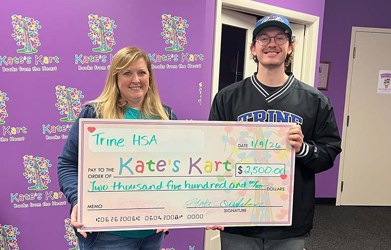 Jennifer Nixon and Hunter Overholser with large check for $2,500