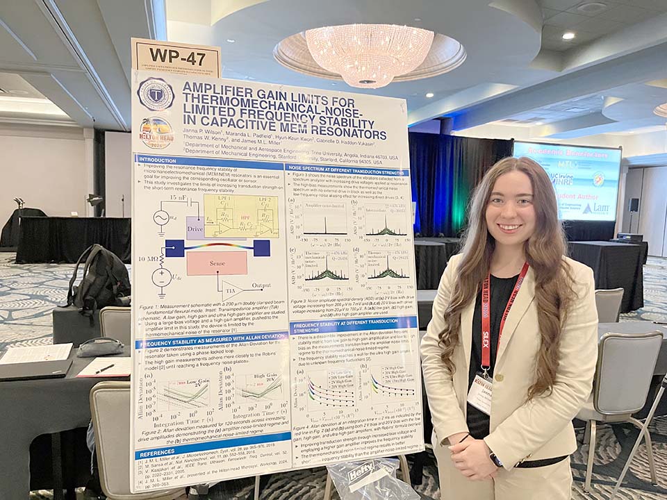 Student standing to the right of research poster