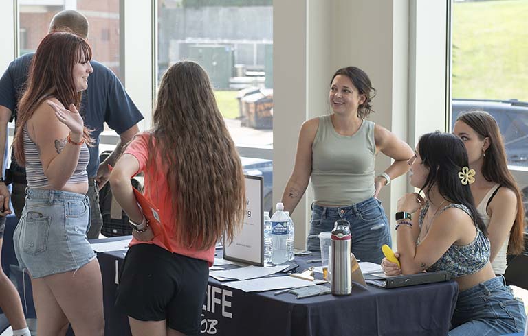 Students talking to company representatives at table