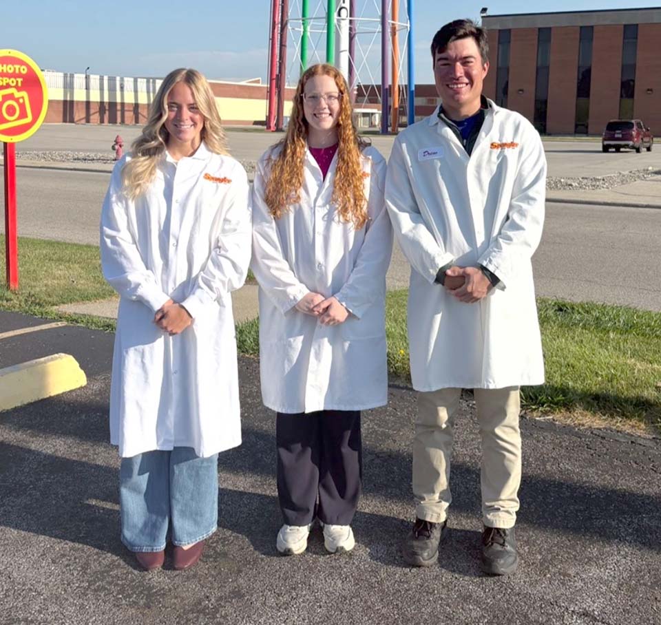 Three students standing in lab coats