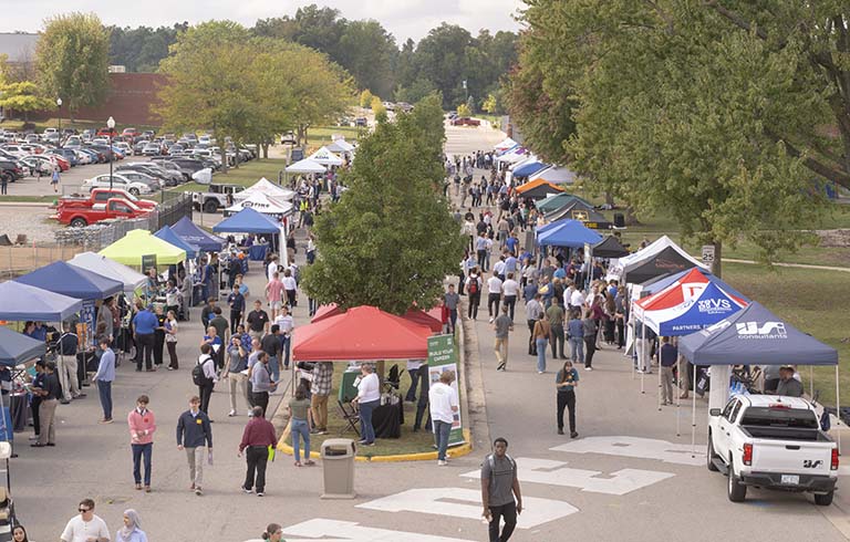 Canopies line a street with people walking up and down the street