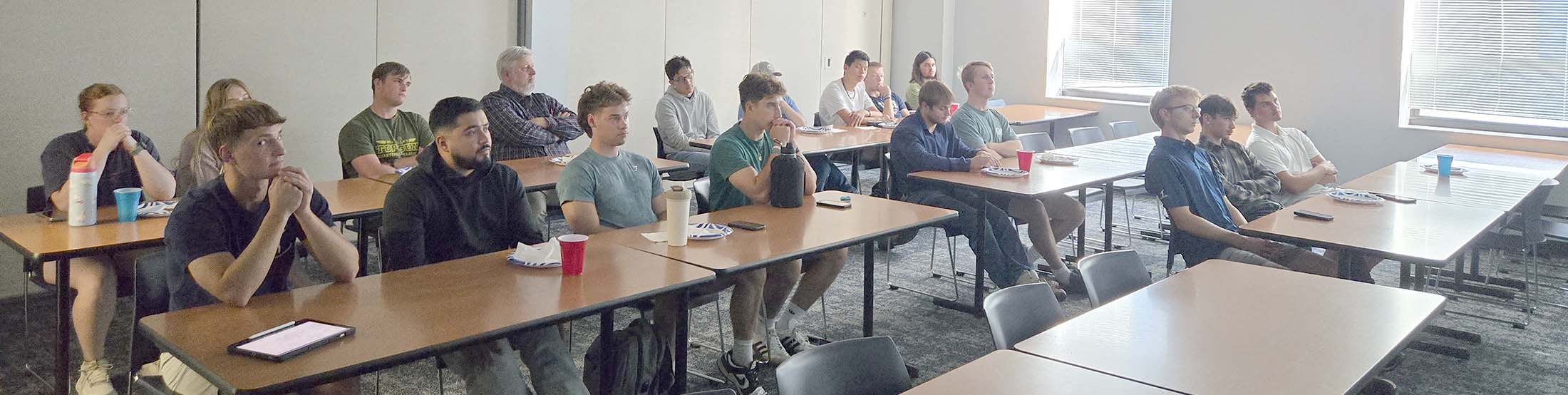 Students seated at desks looking off-camera